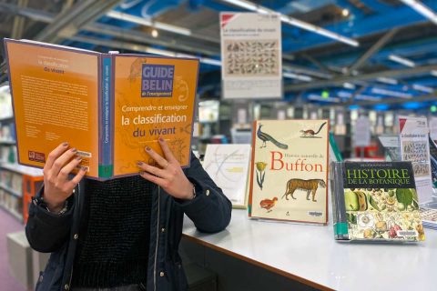 usager consultant un ouvrage dans la bibliothèque