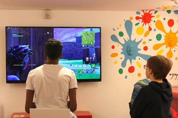 adolescents jouant à fortnite dans le salon jeux vidéo