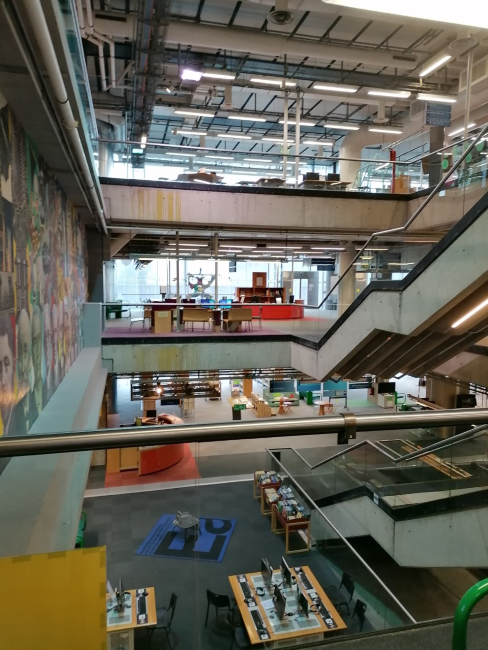 Photographie de l'intérieur de la bibliothèque avec l'escalier qui dessert les différents étages