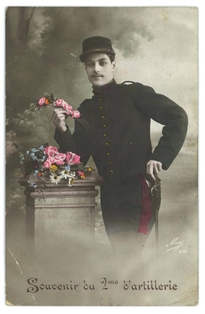 Soldat posant avec des fleurs à la main. Une dédicace : "Souvenirs du 2e d'artillerie".