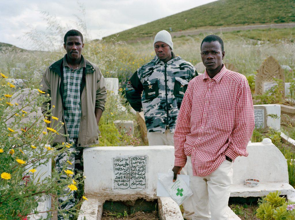 Groupe d'hommes autour de la tombe d'un ami