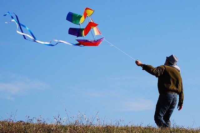 Photographie d'un homme tenant un cerf-volant